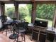 Enjoyable screened porch featuring a grill, outdoor furniture, and a view of lush greenery at 33 Camellia Dr, Ormond Beach, FL 32176