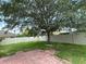 Spacious backyard featuring a large tree, grassy lawn, and a white privacy fence at 3660 Daydream Pl, St Cloud, FL 34772