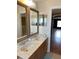 Bathroom featuring a double vanity with granite countertop and two mirrors at 3660 Daydream Pl, St Cloud, FL 34772
