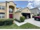 Two-story home featuring a large garage, manicured lawn, stucco exterior, and a red front door at 3660 Daydream Pl, St Cloud, FL 34772