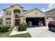 Charming two-story home featuring a red door, a spacious garage, and verdant landscaping at 3660 Daydream Pl, St Cloud, FL 34772