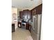Modern kitchen with stainless steel appliances, tile flooring and rich dark wood cabinets at 3660 Daydream Pl, St Cloud, FL 34772