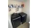 Modern laundry room featuring sleek, black, front-load washer and dryer at 3660 Daydream Pl, St Cloud, FL 34772