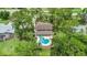 Aerial view of a beautiful home with a uniquely-shaped pool surrounded by trees, with a golf course visible nearby at 428 Pelican Bay Dr, Daytona Beach, FL 32119