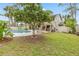 Large backyard featuring a pool, patio, and beautiful, mature landscaping at 428 Pelican Bay Dr, Daytona Beach, FL 32119