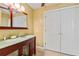 Bathroom featuring dual sinks, custom vanity, large mirror, and tiled floors at 428 Pelican Bay Dr, Daytona Beach, FL 32119