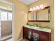 Modern bathroom with dual sinks, custom vanity, large mirror, and tiled walk-in shower at 428 Pelican Bay Dr, Daytona Beach, FL 32119