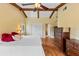 Bedroom featuring wood floors, exposed ceiling beams, ceiling fan, closet, and an ensuite at 428 Pelican Bay Dr, Daytona Beach, FL 32119