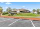 Stunning view of the community clubhouse with beautiful landscaping and ample parking at 428 Pelican Bay Dr, Daytona Beach, FL 32119