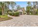 Beautiful home featuring a stone chimney, a paved driveway, and well-manicured landscaping at 428 Pelican Bay Dr, Daytona Beach, FL 32119