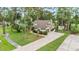 An aerial view of a charming home with a stone chimney, manicured landscaping, and a brick driveway at 428 Pelican Bay Dr, Daytona Beach, FL 32119