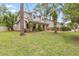 Charming home featuring stone accents, mature trees, and an expansive front yard at 428 Pelican Bay Dr, Daytona Beach, FL 32119