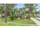 Traditional home with mature landscaping, stone accents, and a paver driveway at 428 Pelican Bay Dr, Daytona Beach, FL 32119