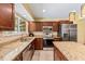 Traditional kitchen features granite counters, stainless steel appliances, tile floors, and wood cabinets at 428 Pelican Bay Dr, Daytona Beach, FL 32119