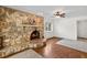 Living room features a stone fireplace, hardwood floors, an area rug, and natural light at 428 Pelican Bay Dr, Daytona Beach, FL 32119