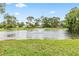 Picturesque pond view highlighting mature trees, manicured lawn, and a relaxing fountain at 428 Pelican Bay Dr, Daytona Beach, FL 32119