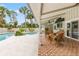 Covered patio featuring wicker furniture, a pool and palm trees at 428 Pelican Bay Dr, Daytona Beach, FL 32119