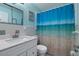 Bathroom featuring a white vanity, framed mirror, tiled backsplash, and shower with a decorative ocean-themed curtain at 999 16Th St, Edgewater, FL 32132