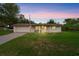 Charming single-story home boasts a well-kept lawn, garage, and a quaint front porch at twilight at 999 16Th St, Edgewater, FL 32132