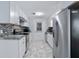 Galley kitchen features white cabinets, subway tile backsplash, and stainless steel appliances at 999 16Th St, Edgewater, FL 32132