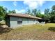 Backyard view of the home featuring a screened lanai and green lawn at 1561 Copperfield Ave, Deltona, FL 32738