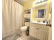 Well-lit bathroom with a shower, white vanity, and mirrored medicine cabinet at 1561 Copperfield Ave, Deltona, FL 32738