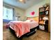 Bright bedroom with a pink blanket, natural light, and wooden shelf for storage at 1561 Copperfield Ave, Deltona, FL 32738