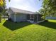 A cozy home featuring a screened-in lanai, a fenced yard, and a well-maintained lawn at 1810 Western Rd, South Daytona, FL 32119