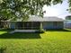 Charming home featuring a screened-in lanai and a spacious, well-maintained backyard with lush green grass at 1810 Western Rd, South Daytona, FL 32119