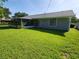 Expansive backyard featuring lush green grass and a screened-in porch, perfect for outdoor enjoyment at 1810 Western Rd, South Daytona, FL 32119