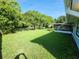 Spacious backyard with a well-maintained lawn, mature trees, and a screened-in porch for relaxation at 1810 Western Rd, South Daytona, FL 32119