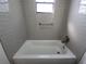 Bathroom featuring a shower-tub combo with gray tile and a safety bar at 1810 Western Rd, South Daytona, FL 32119