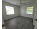 Bright bedroom features wood-look flooring, a ceiling fan, and large windows at 1810 Western Rd, South Daytona, FL 32119