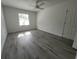 Bedroom featuring wood-look floors, ceiling fan, white walls, and a window with blinds at 1810 Western Rd, South Daytona, FL 32119