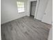 Bedroom featuring durable wood-look flooring and a closet, plus a large window at 1810 Western Rd, South Daytona, FL 32119
