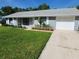 Well-kept single-story home featuring an attached garage, a pristine lawn, and a concrete driveway at 1810 Western Rd, South Daytona, FL 32119
