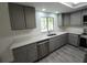 Contemporary kitchen with grey cabinets, quartz countertops, stainless steel appliances, and modern flooring at 1810 Western Rd, South Daytona, FL 32119