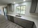 Updated kitchen featuring grey cabinets, modern appliances, a large window, and durable flooring at 1810 Western Rd, South Daytona, FL 32119