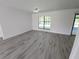 Bright living room with wood-look floors, white walls, and natural light from the window at 1810 Western Rd, South Daytona, FL 32119