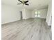 Spacious living room boasts gray wood-look floors, ceiling fan, and a window with natural light at 1810 Western Rd, South Daytona, FL 32119