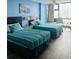 Bright bedroom with two queen beds, a ceiling fan, and a large window offering city views at 1909 S Atlantic Ave # 405/406, Daytona Beach Shores, FL 32118