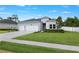 Attractive one-story home with a three-car garage, complemented by lush lawn and mature landscaping at 2137 Raglan Cir, Ormond Beach, FL 32174