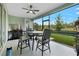 Relaxing screened-in patio with comfortable seating, a ceiling fan, and views of the lush backyard at 2137 Raglan Cir, Ormond Beach, FL 32174