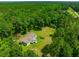 Aerial view of a rural home on sprawling lot surrounded by lush greenery and tall trees at 21375 Nw 150Th Avenue Rd, Micanopy, FL 32667