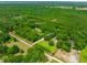 Aerial view of a large property with a main house and mother-in-law suite surrounded by lush greenery at 21375 Nw 150Th Avenue Rd, Micanopy, FL 32667