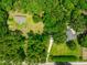 Expansive aerial view of properties, lush landscaping, and driveway access at 21375 Nw 150Th Avenue Rd, Micanopy, FL 32667