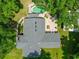 Aerial view of the roof and backyard featuring an in-ground pool, lush lawn, and brick patio at 21375 Nw 150Th Avenue Rd, Micanopy, FL 32667