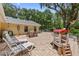Brick patio with lawn chairs, picnic table, and outdoor games for Gathering fun in this charming backyard at 21375 Nw 150Th Avenue Rd, Micanopy, FL 32667