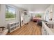Spacious bedroom featuring hardwood-style floors, large mirror, and a crib for the little ones at 21375 Nw 150Th Avenue Rd, Micanopy, FL 32667