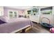 Cozy bedroom featuring light purple walls, hardwood-style flooring, and ample natural light at 21375 Nw 150Th Avenue Rd, Micanopy, FL 32667